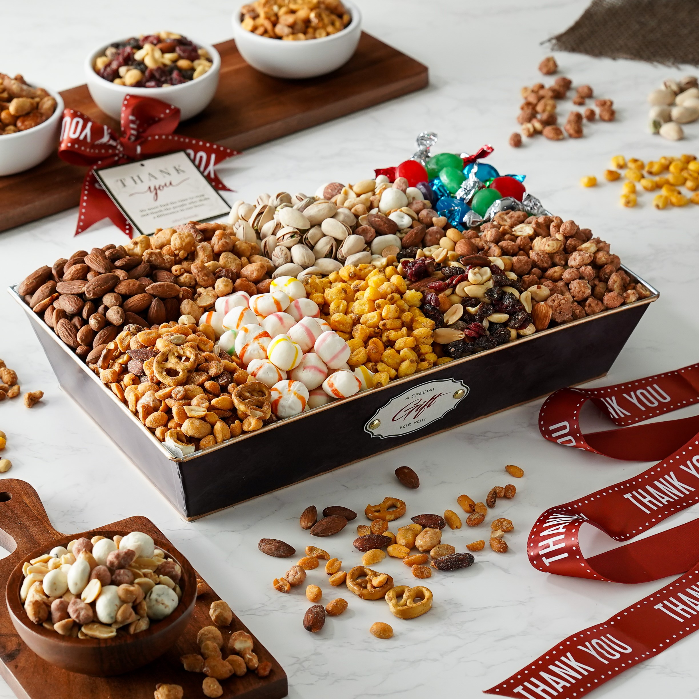 Multi section tray filled with ten different hand size snacks including nuts and chocolate